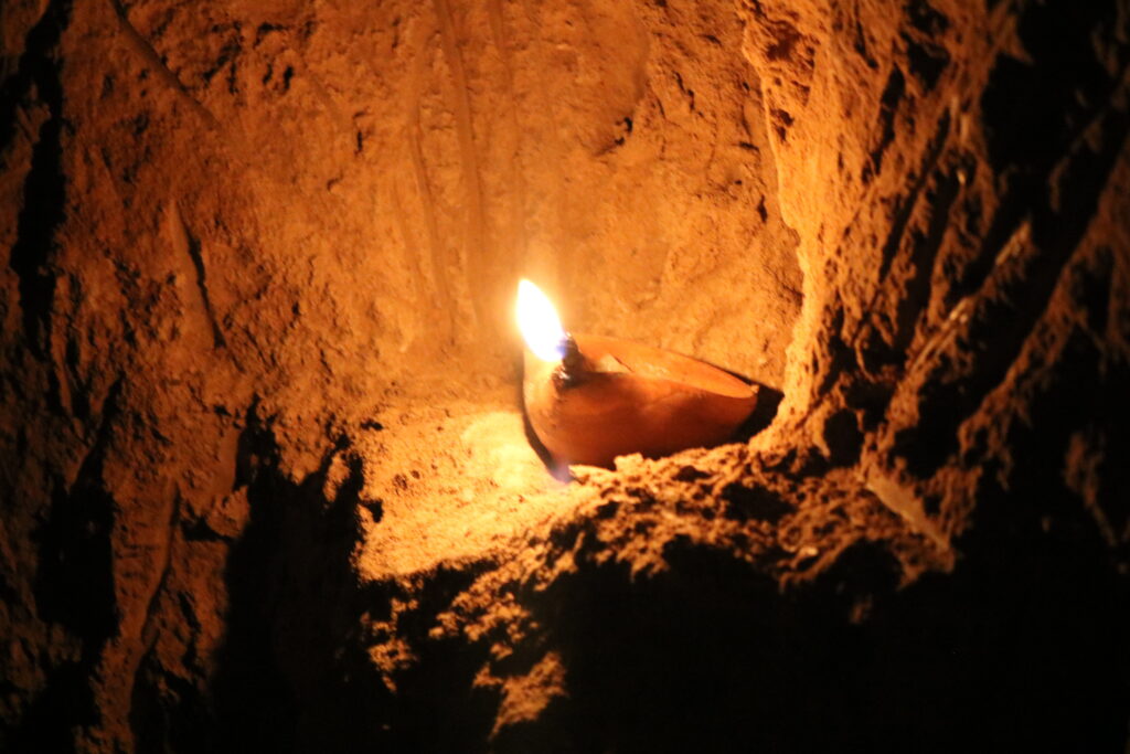 Lit tallow lamp in a historical qanat