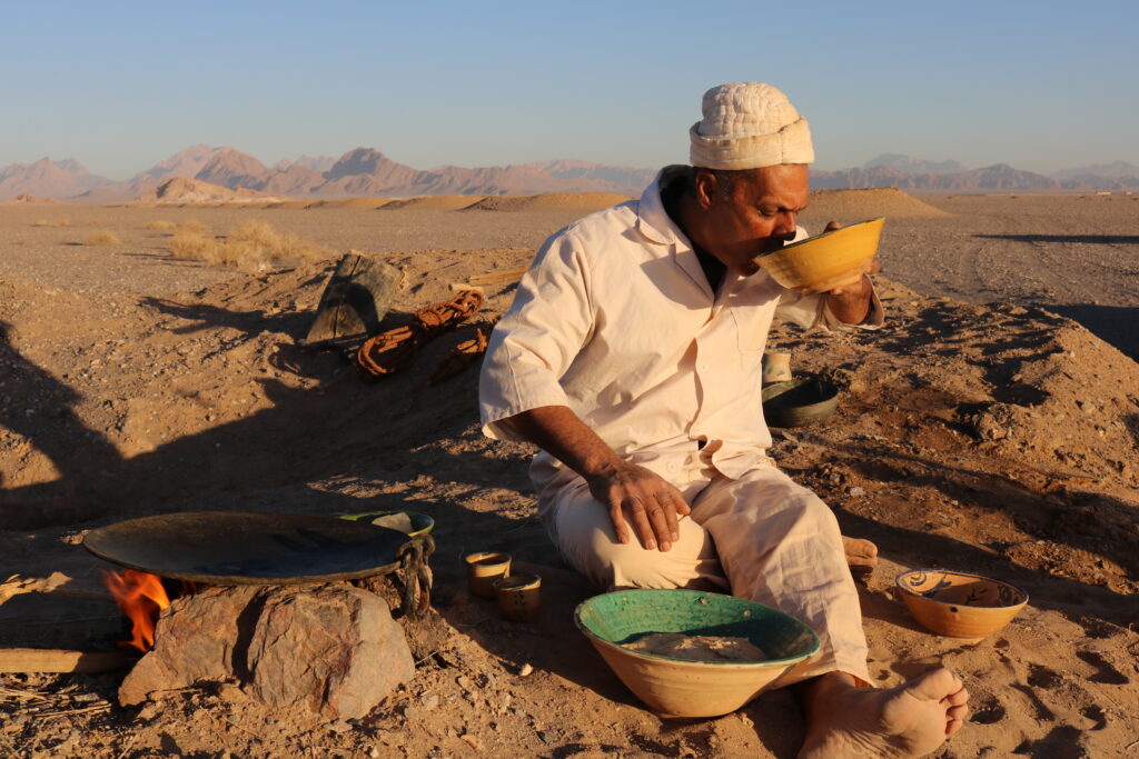 A moghanian drinking water while enjoying traditional Latir dough